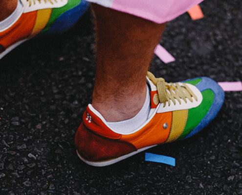 Rainbow colored confetti and shoes on a city street